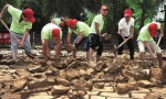 7月13日，长沙市芙蓉区走马楼社区的志愿者在橘子洲景区沙滩乐园清理淤泥，为开园做准备。  傅聪摄 - 新浪湖南