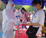 资料图：2020年7月7日，河南郑州，医务人员为进入考点的考生进行体温检查和消毒。河南省卫健委供图 - 新浪湖南