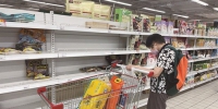 8月15日，消费者正在家乐福贺龙店购物，其身后的货架大多处于空置状态。 - 新浪湖南