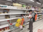 8月15日，消费者正在家乐福贺龙店购物，其身后的货架大多处于空置状态。 - 新浪湖南